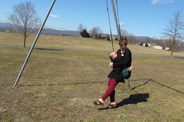 a mother and young daughter swinging