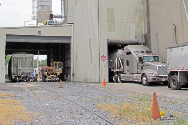 grain car, railcar mover, and truck at bays at George's
